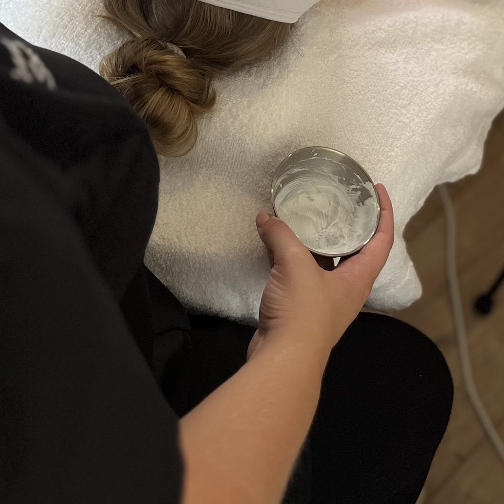 Solène houdt een potje masker vast tijdens een gezichtsbehandeling